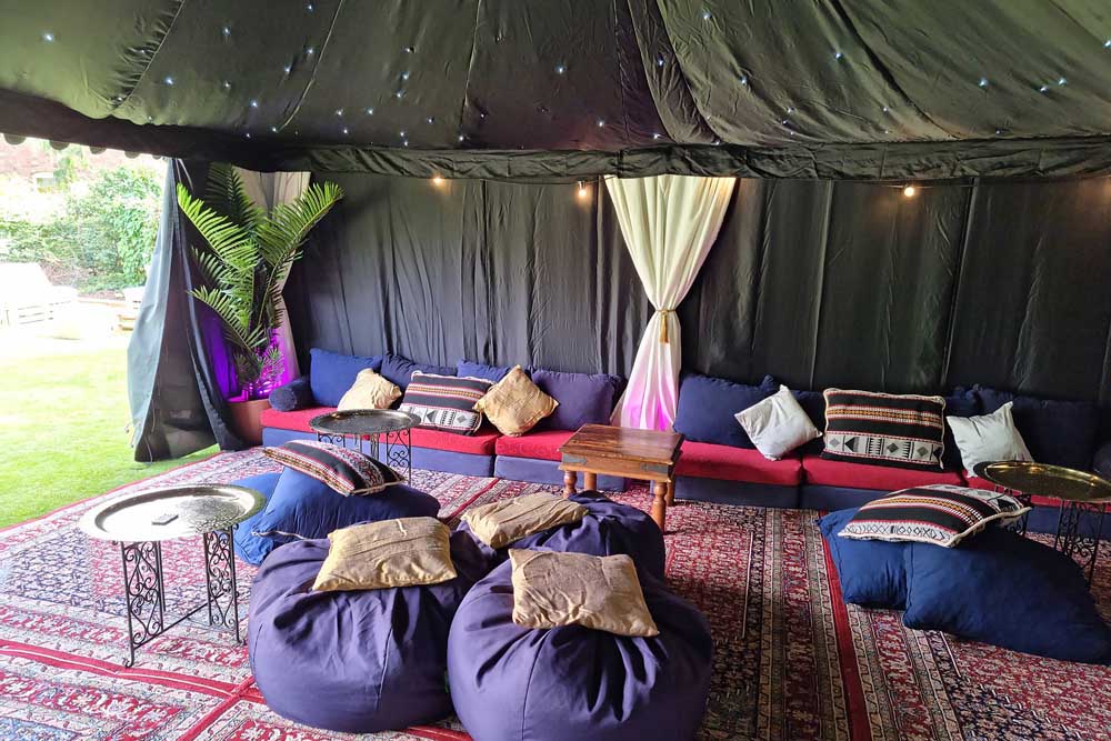 A 9x6m Arabian Tent with a Starcloth Lining and Colourful Low-Level Seating Cushions.